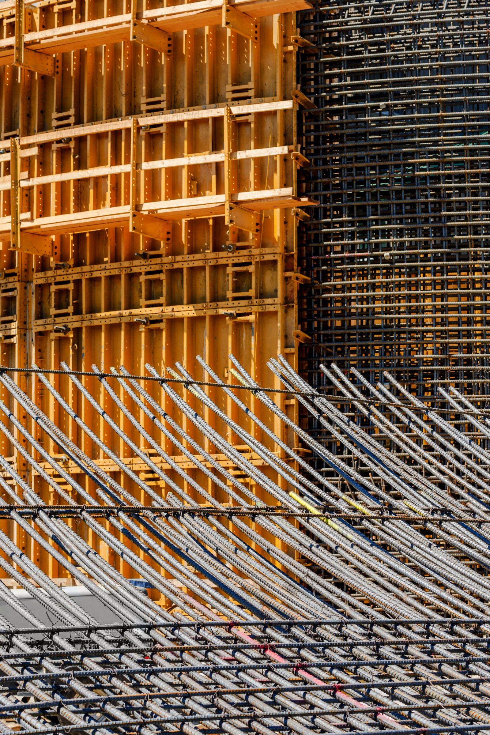 The exterior of a construction site, a high rise building, rebar concrete shuttering and metal mesh grids for building.